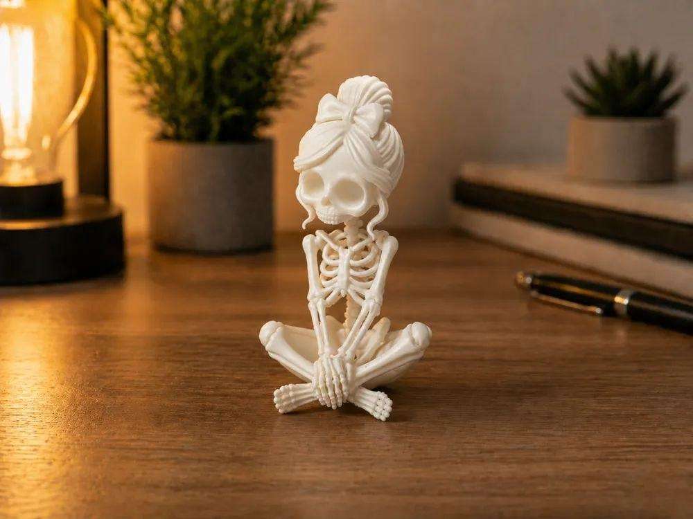 A figurine of a seated female skeleton